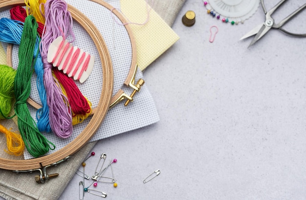Kolorowe nici i igły na drewnianym stole